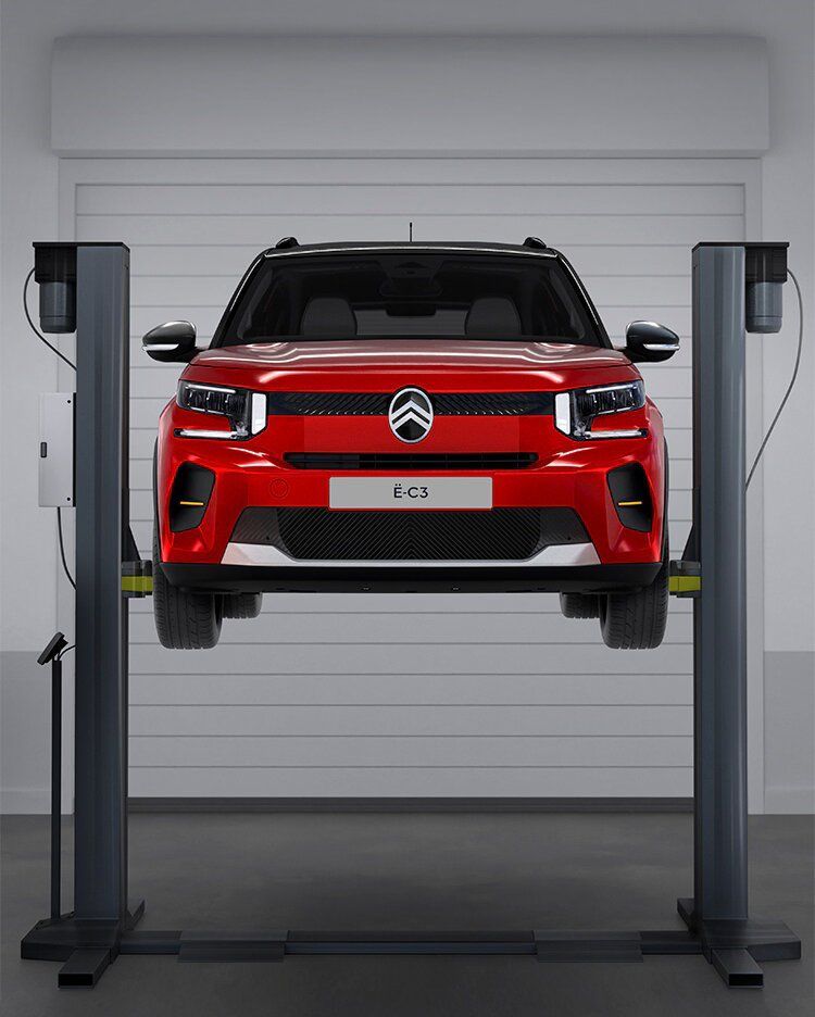 Véhicule Citroën rouge sur un pont élévateur dans un garage
