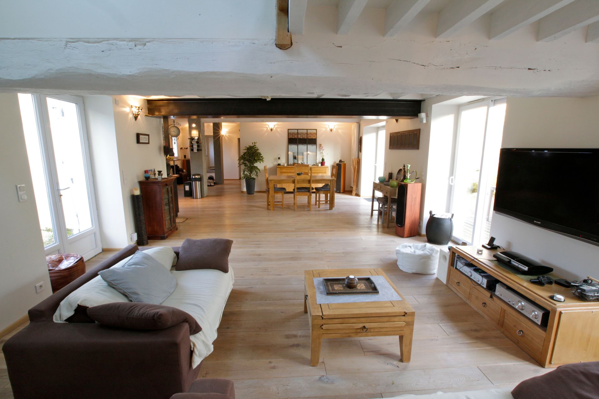 Intérieur d'une maison dans les tons beiges et une salle à manger en arrière-plan.