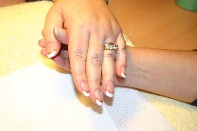 Eine Nahaufnahme der Hand einer Frau mit einem Ring daran.