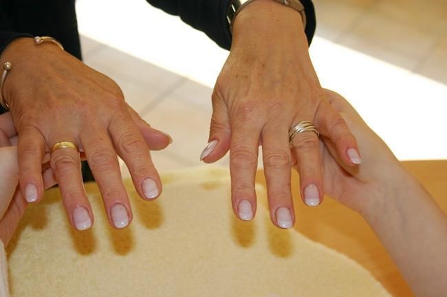 Eine Frau mit einem goldenen Ring am Finger berührt die Hand einer anderen Frau