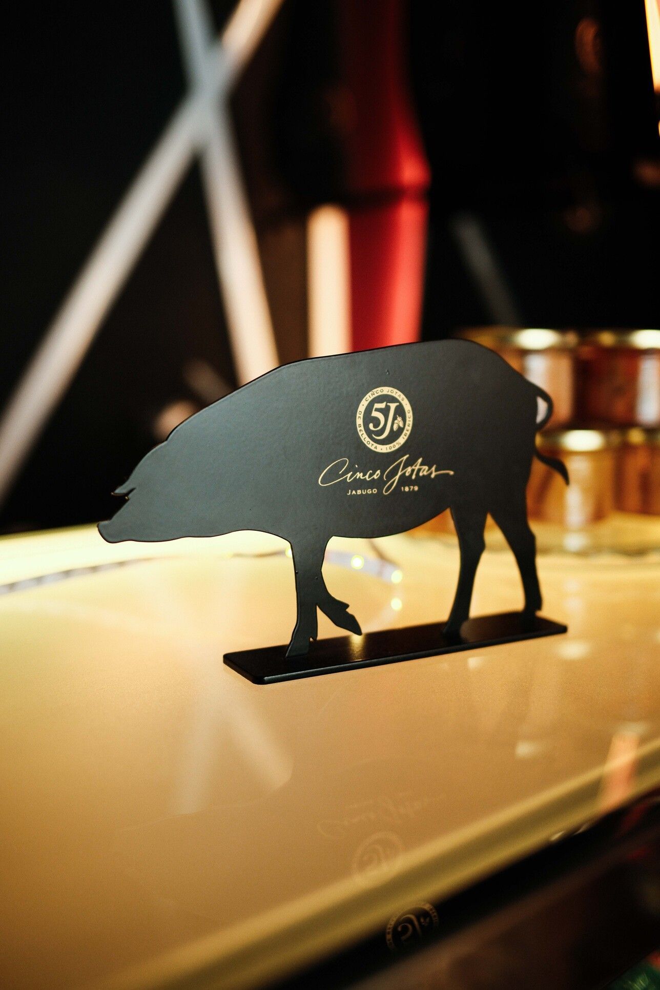 Letrero negro en forma de jabalí con logotipo dorado, 