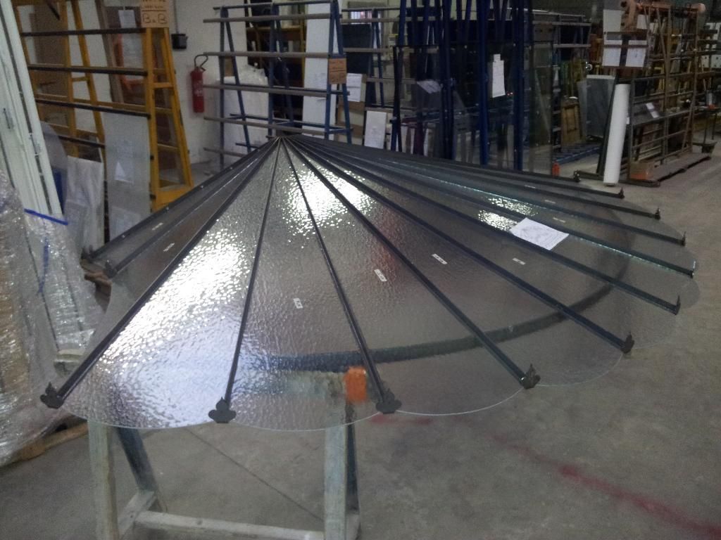 Structure de toit circulaire transparente avec supports noirs, à l'intérieur.