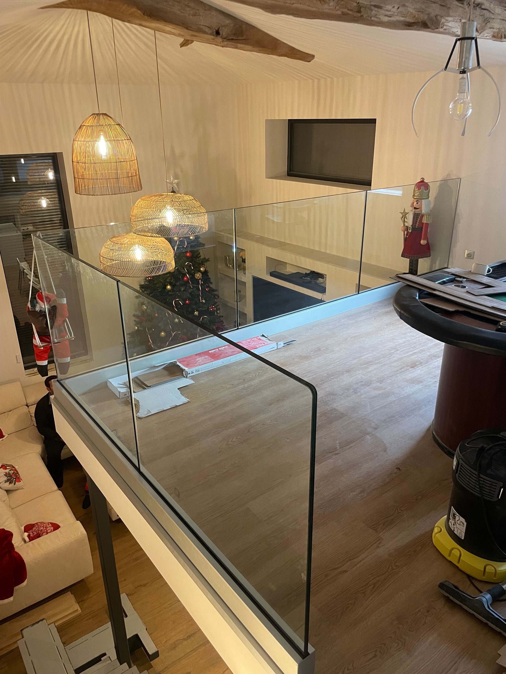 Des boutiques aux volets roulants et des présentoirs de vêtements sont disposés sur une allée claire, sous la façade d'un immeuble à volets.