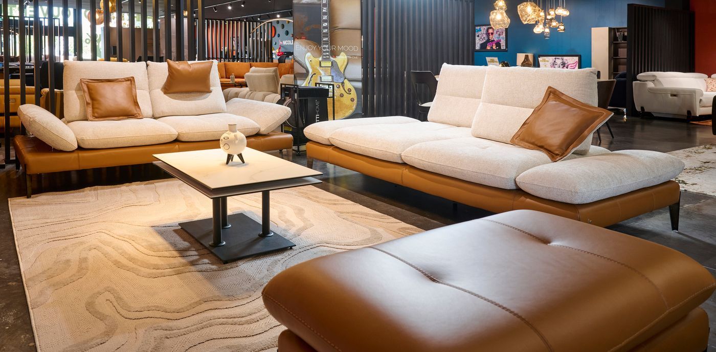 Un canapé en cuir marron et tissu blanc