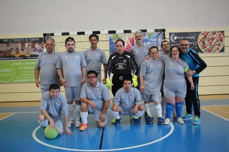 Un groupe de personnes pose pour une photo sur un terrain de football.
