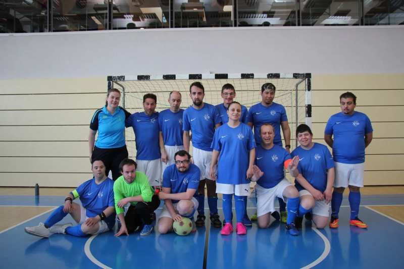 Un groupe de personnes pose pour une photo sur un terrain de football.