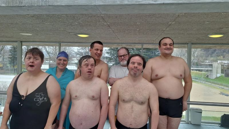 Un groupe de personnes debout les unes à côté des autres dans une piscine.