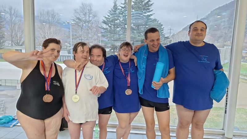 Un groupe de personnes pose pour une photo dans une piscine.