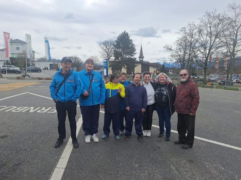 Un groupe de personnes pose pour une photo sur un parking.