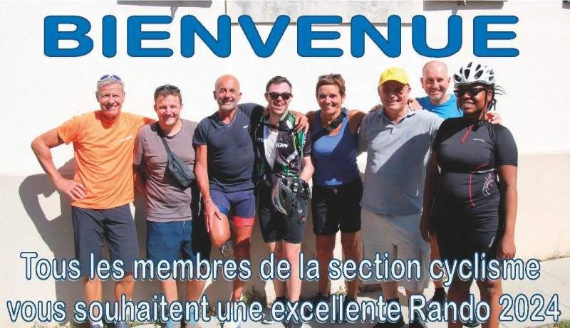 Un groupe de personnes pose pour une photo devant un panneau indiquant 