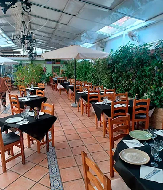 Un restaurante con muchas mesas y sillas.