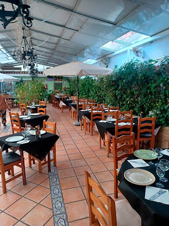 Un restaurante con muchas mesas y sillas.