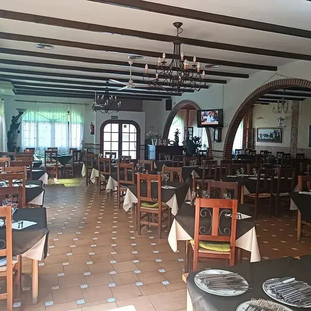 Un gran comedor con mesas y sillas y un televisor.