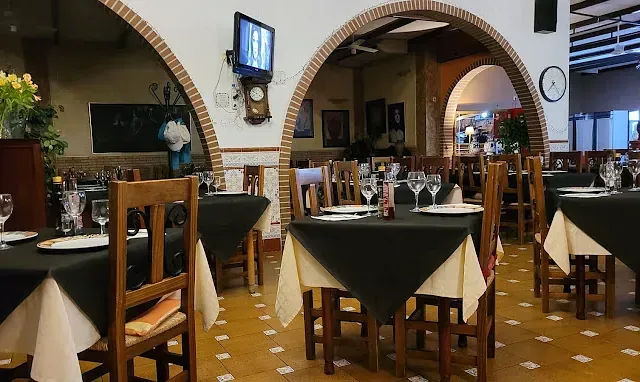 Un restaurante con mesas y sillas y un reloj en la pared.
