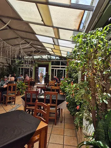 Un restaurante con mesas y sillas y un dosel sobre las mesas.