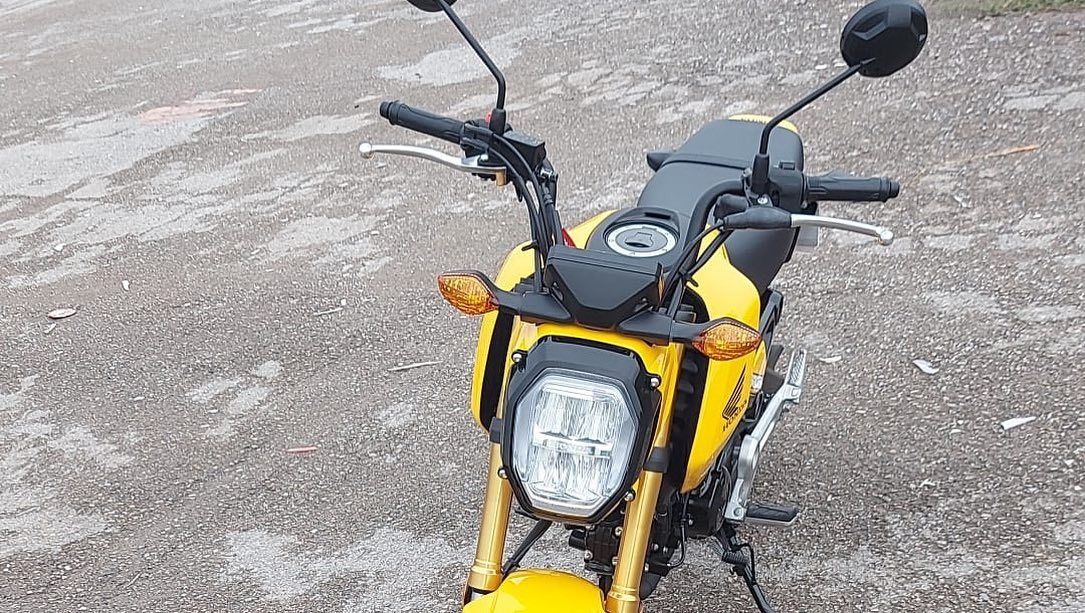 Una motocicleta amarilla y negra está estacionada al costado de la carretera.