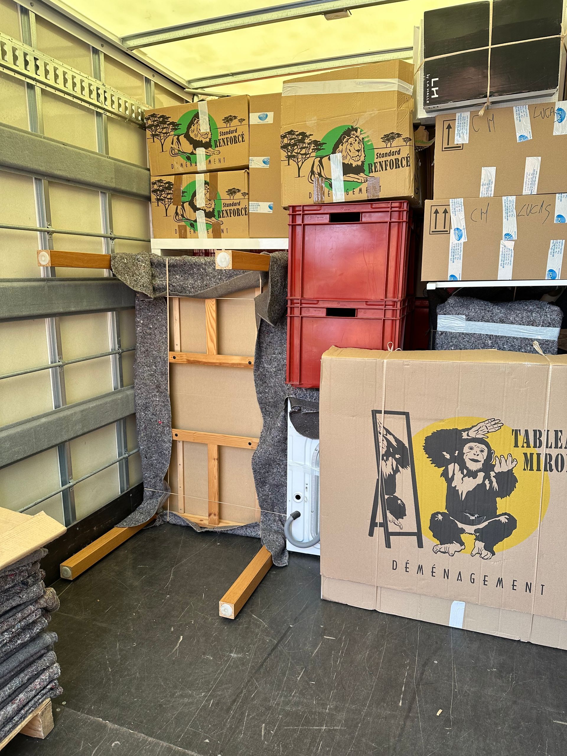 Intérieur de camion rempli de cartons, caissons et meubles emballés dans des couvertures