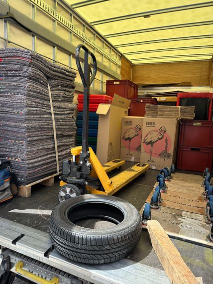Intérieur d'un camion de déménagement avec pile de couverture, carton et transpalette
