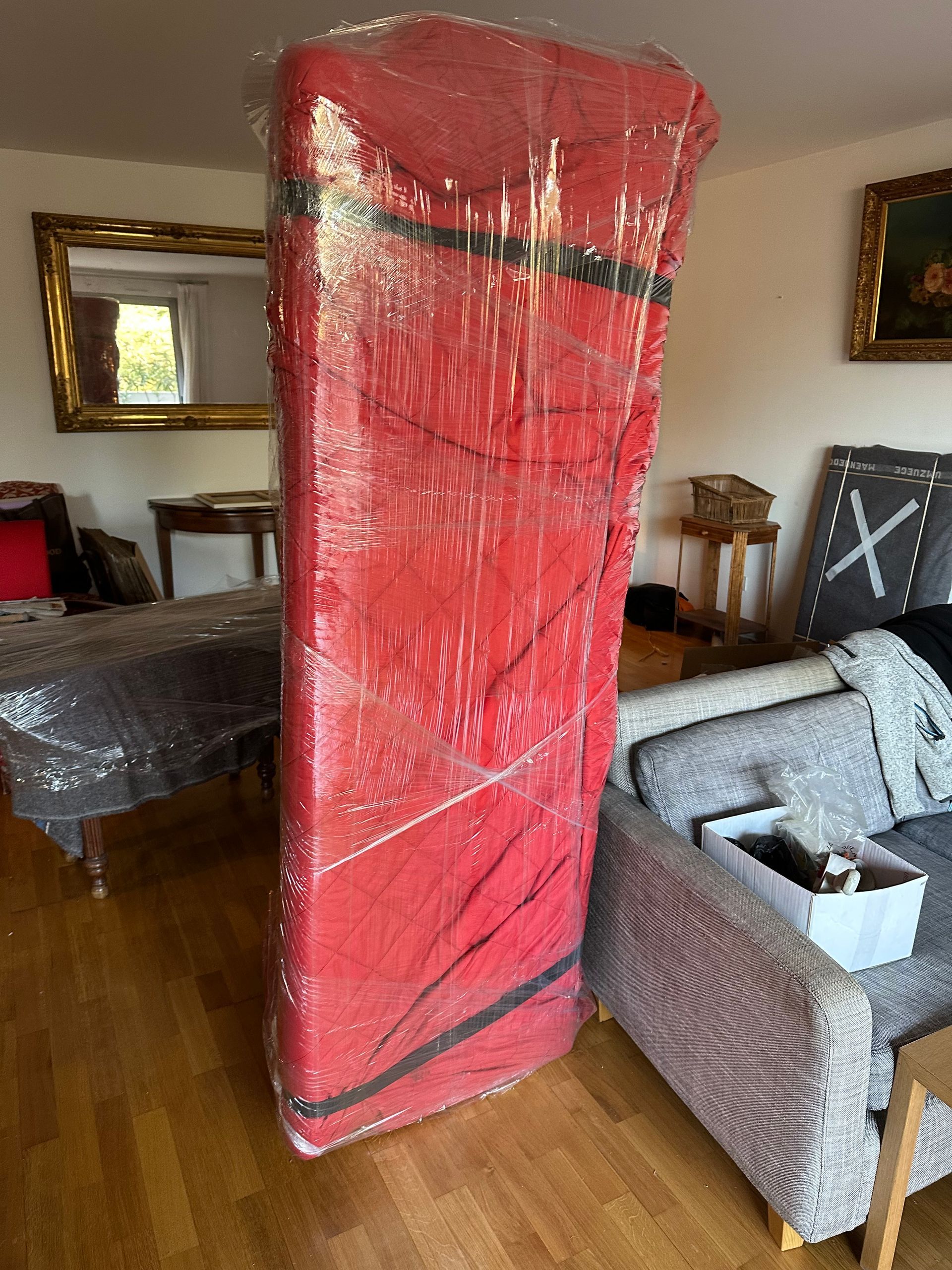 Déménagement en cours avec mobiliers emballés sous couvertures et film étirable