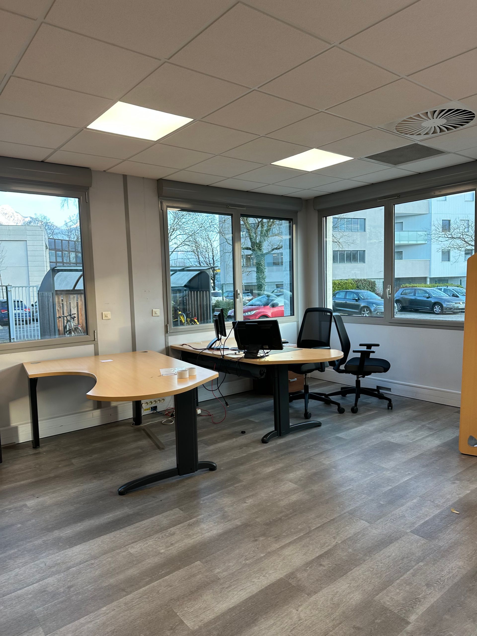 Un bureau vide et un autre bureau avec 2 chaises et 2 écrans d'ordinateur