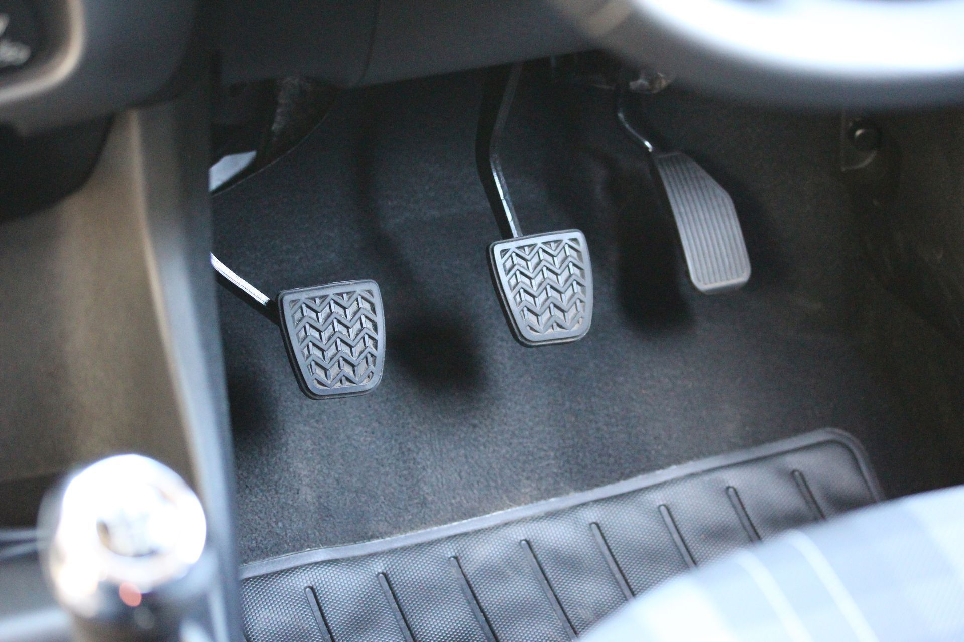 Pédales de voiture : embrayage, frein et accélérateur, visibles à l’intérieur du véhicule.