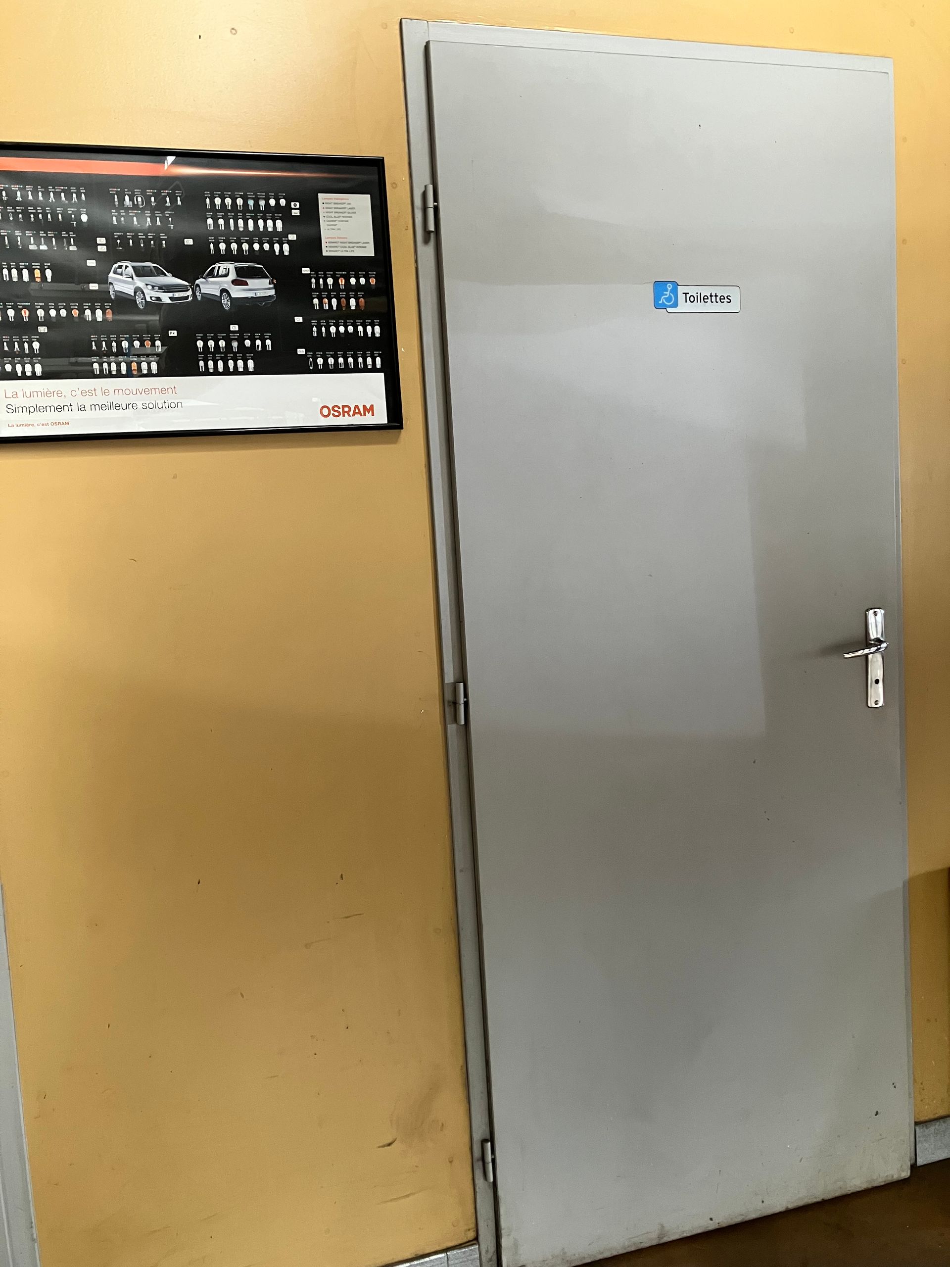 Porte des toilettes avec accès PMR.