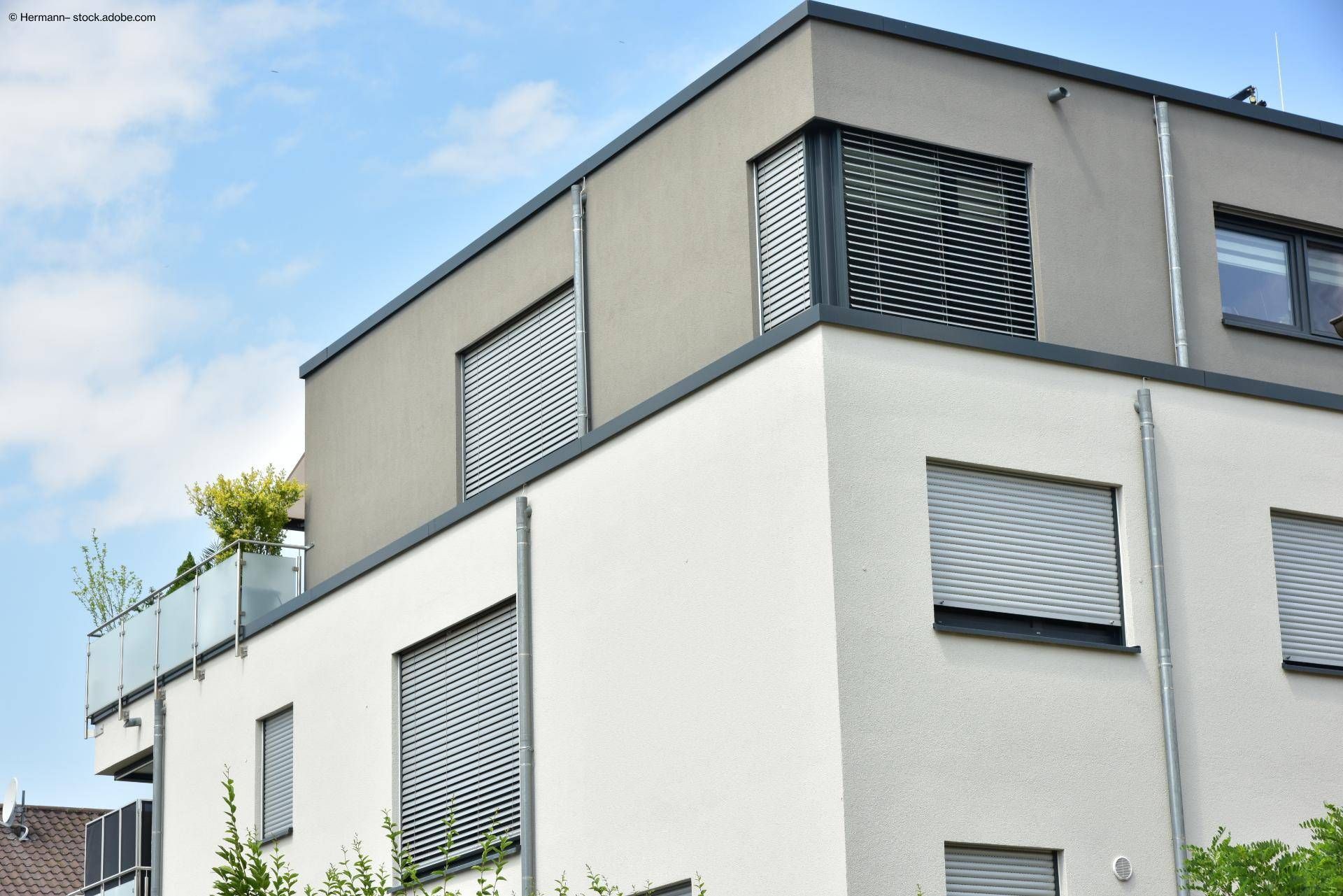 Haus von außen: viele Fenster mit Rollladen herunter