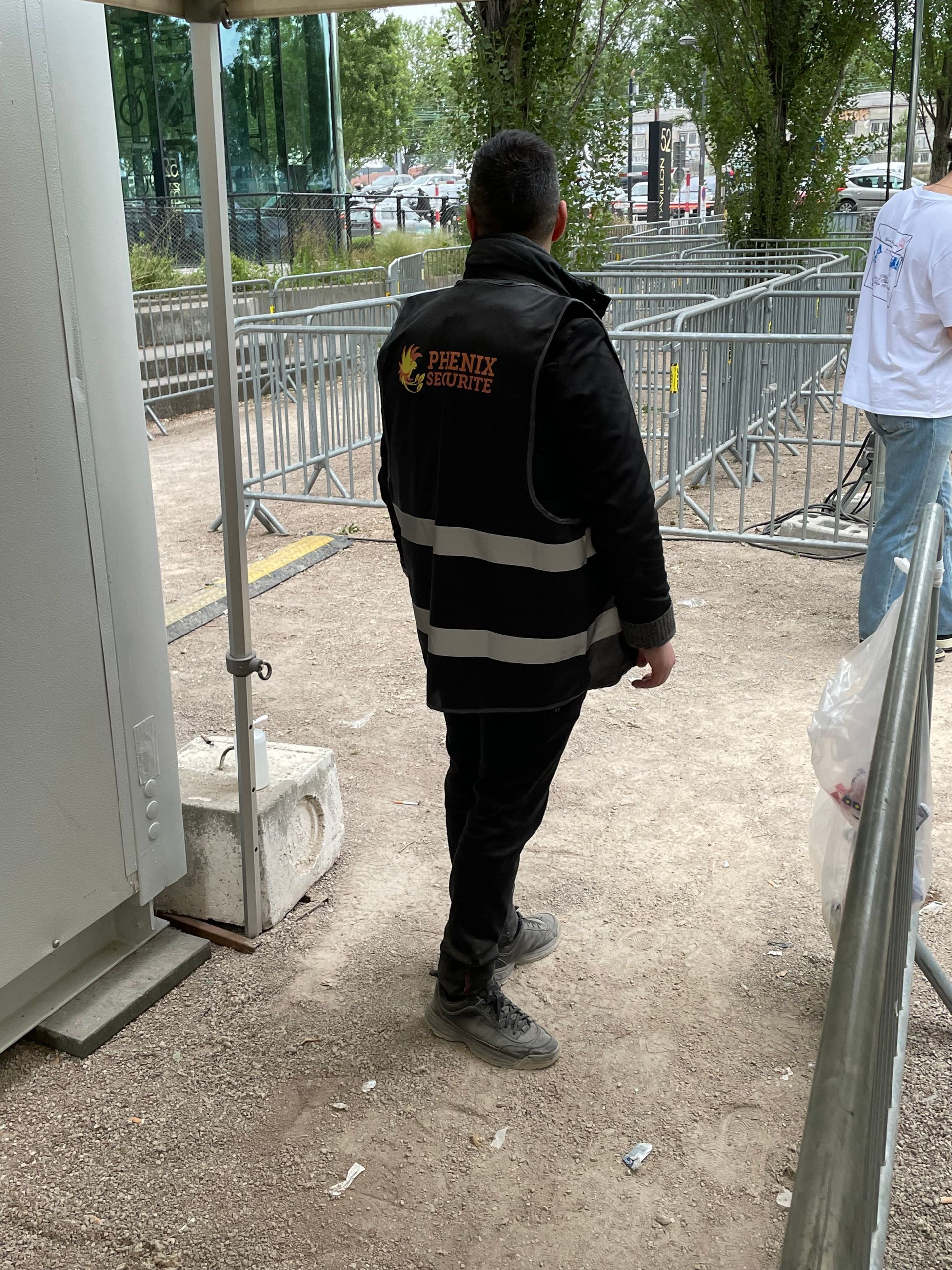 Agent de sécurité de dos portant une veste Phénix Sécurité