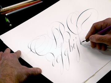 La main de Laurent Rébéna qui écrit un texte en calligraphie