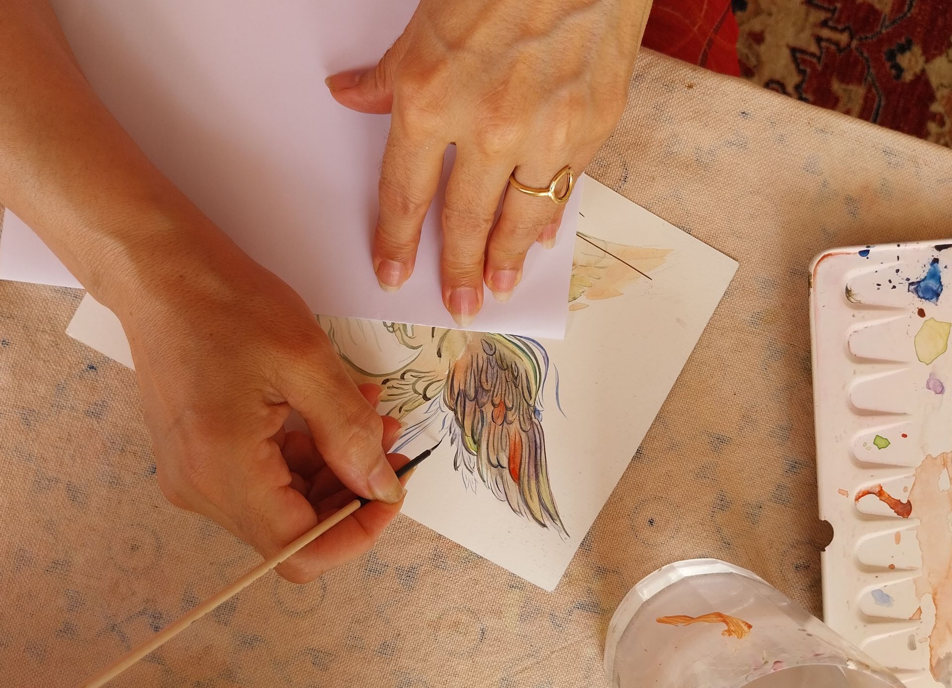 Les doigts de Béatrice Balloy qui tiennent un outil de dessin