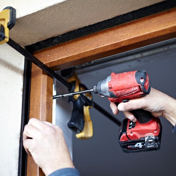 Perceuse fixe un cadre de fenêtre
