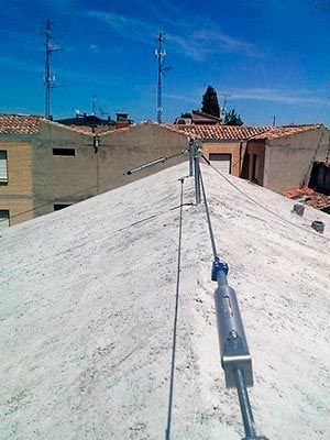 Un techo con muchos cables y un cielo azul al fondo.