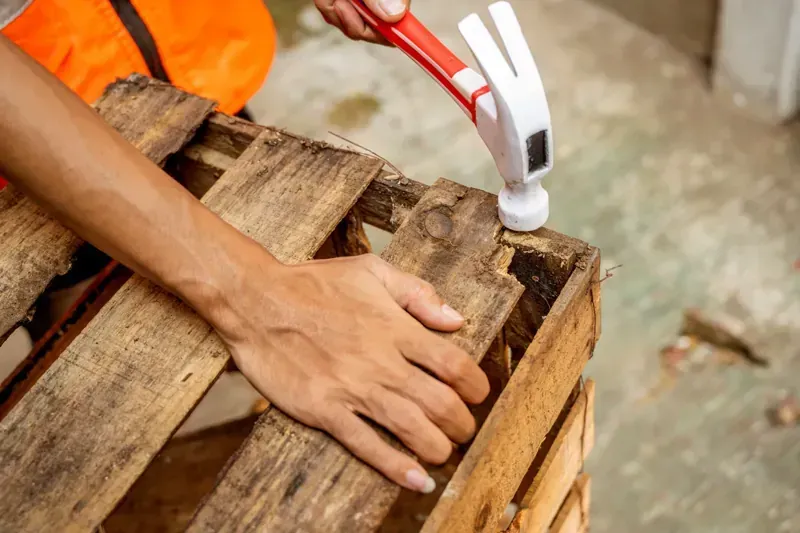 Pilas de palés de madera para envíos en varios tonos de marrón y tostado.