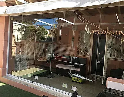 Un escaparate con un gran cristal roto, que deja ver estanterías y objetos en el interior de la tienda.