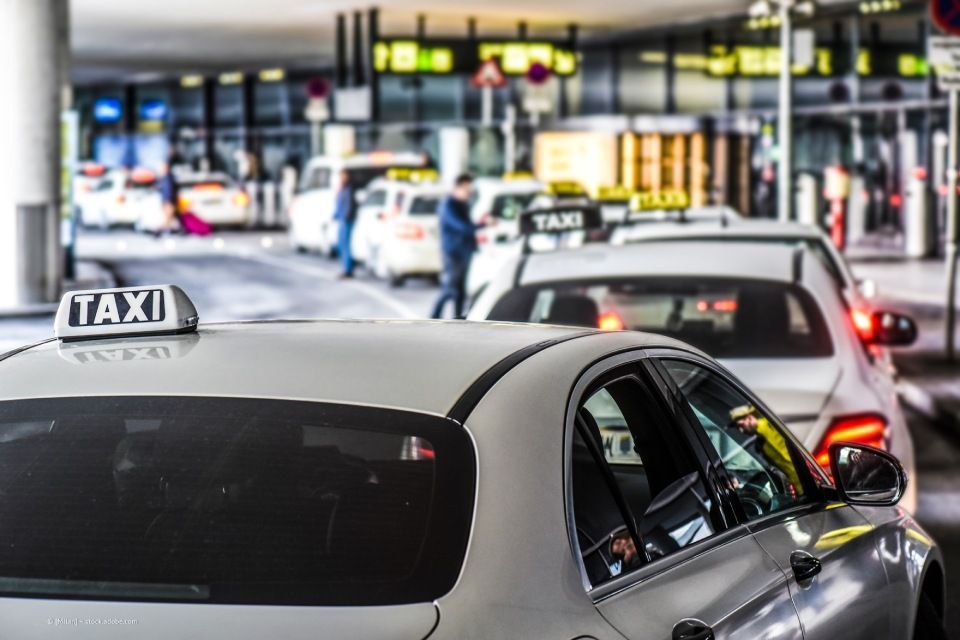 Mehrere Taxis vor einem Flughafen-Terminal – Taxi Schlayer