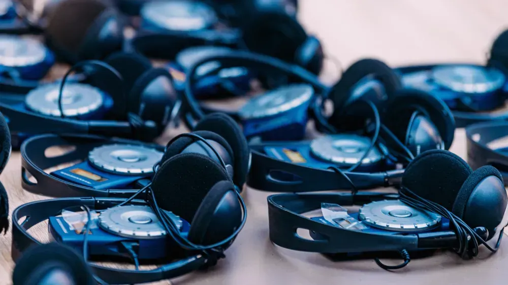 Vários fones de ouvido estão sobre uma mesa.