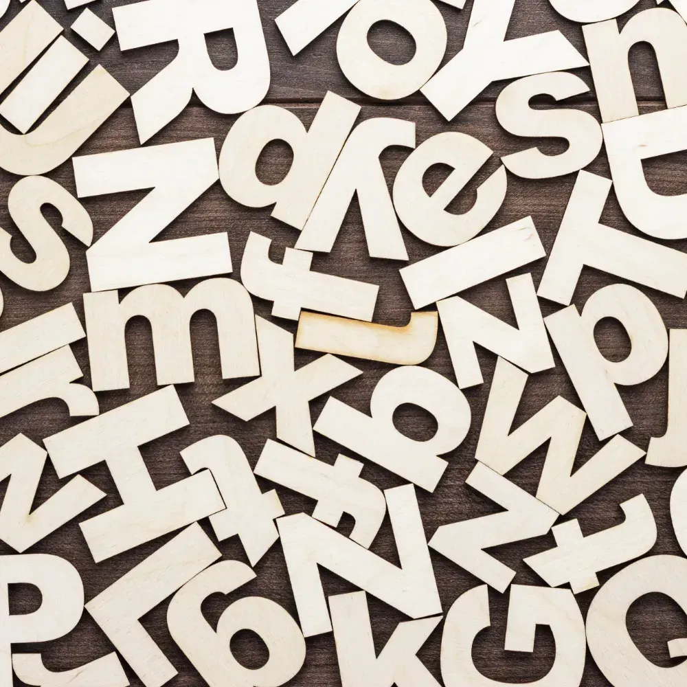 Uma pilha de letras de madeira sobre uma mesa de madeira.