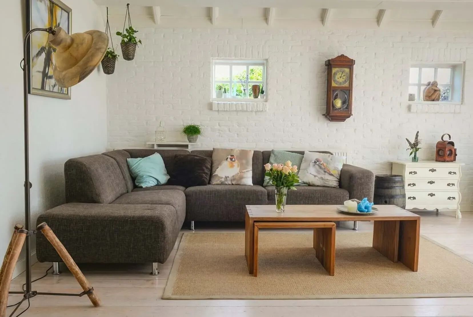 Uma sala de estar com um sofá, duas mesas de centro e um relógio na parede.