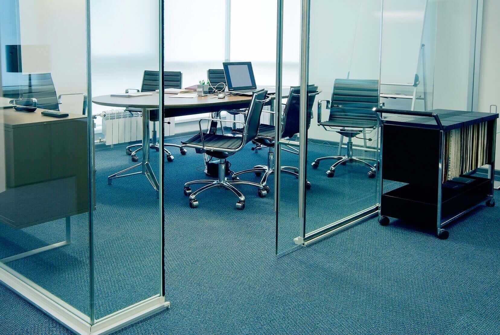 Uma sala de conferências com uma parede de vidro e piso em carpete