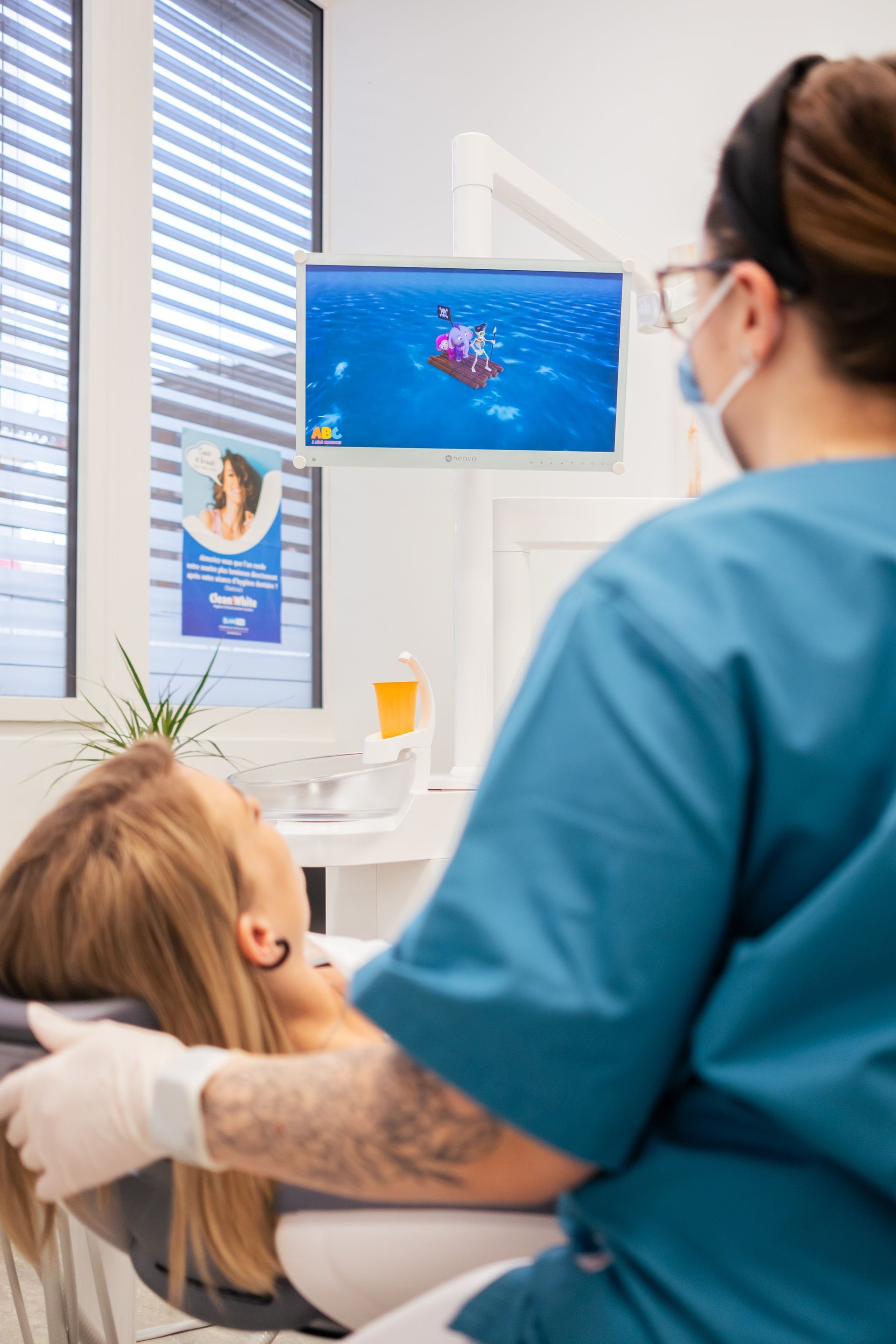 Un dentiste examine les dents blanches et éclatantes d'un patient à l'aide d'un miroir ; tous deux sourient.