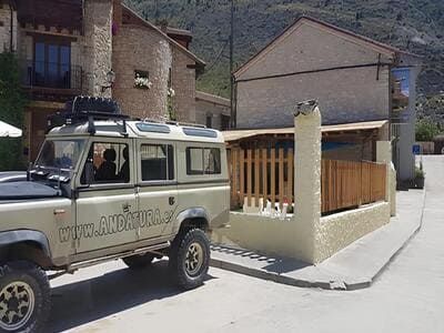Una 4x4 color canela estacionada en la calle frente a los edificios. 