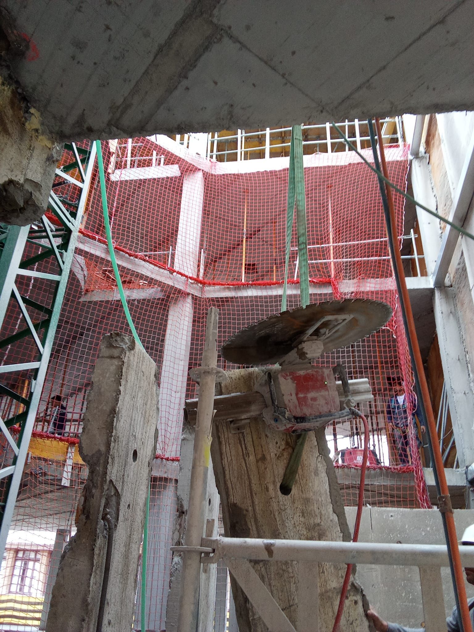 Andamios y redes de seguridad rojas alrededor de la abertura de un edificio en construcción.