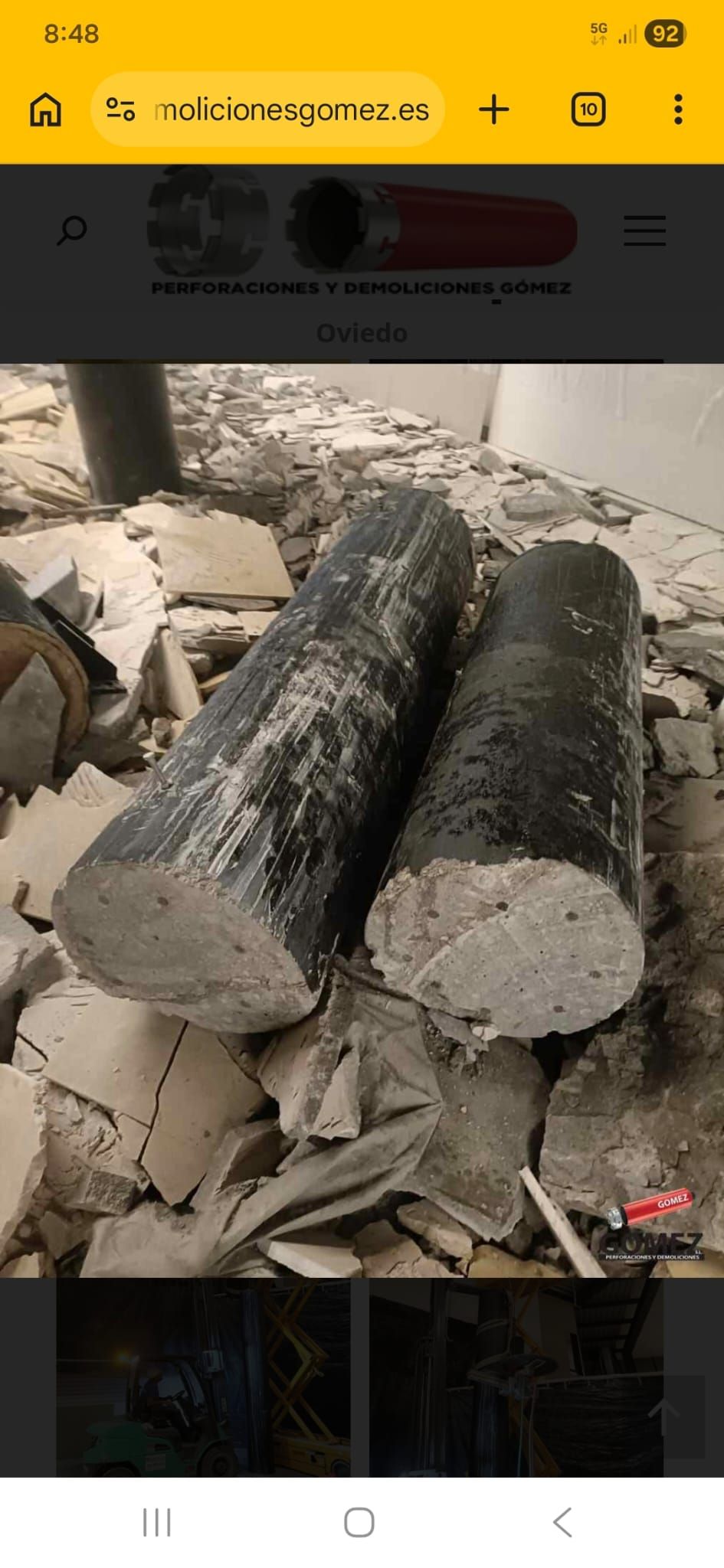 Dos grandes troncos cortados apilados sobre un suelo tosco, con trozos de madera más pequeños cerca.
