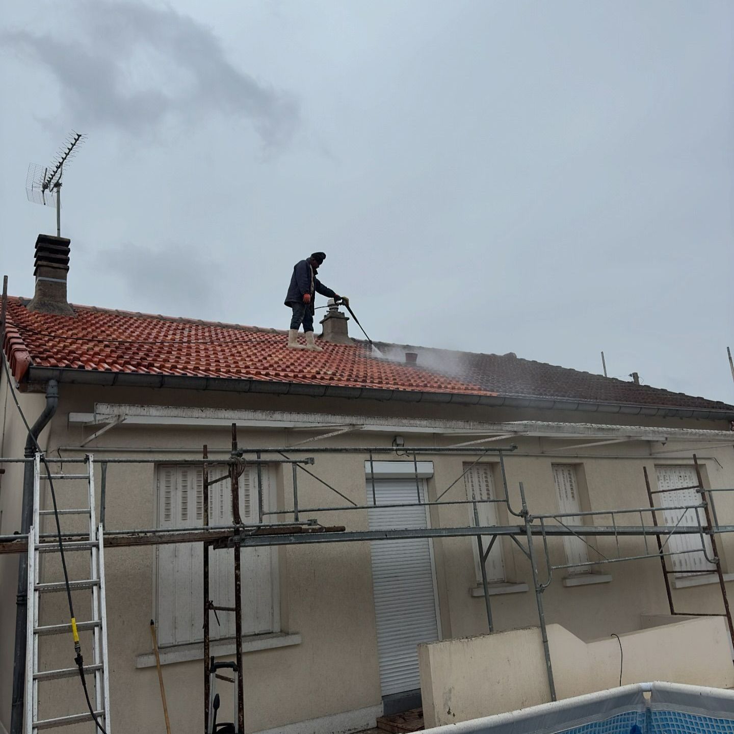 Un homme pulvérisant un traitement sur toiture