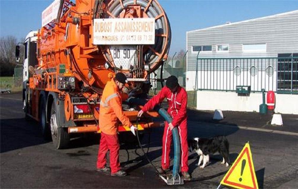 Deux employés de Dubost Assainissement procédant à la vidange d'une fosse septique