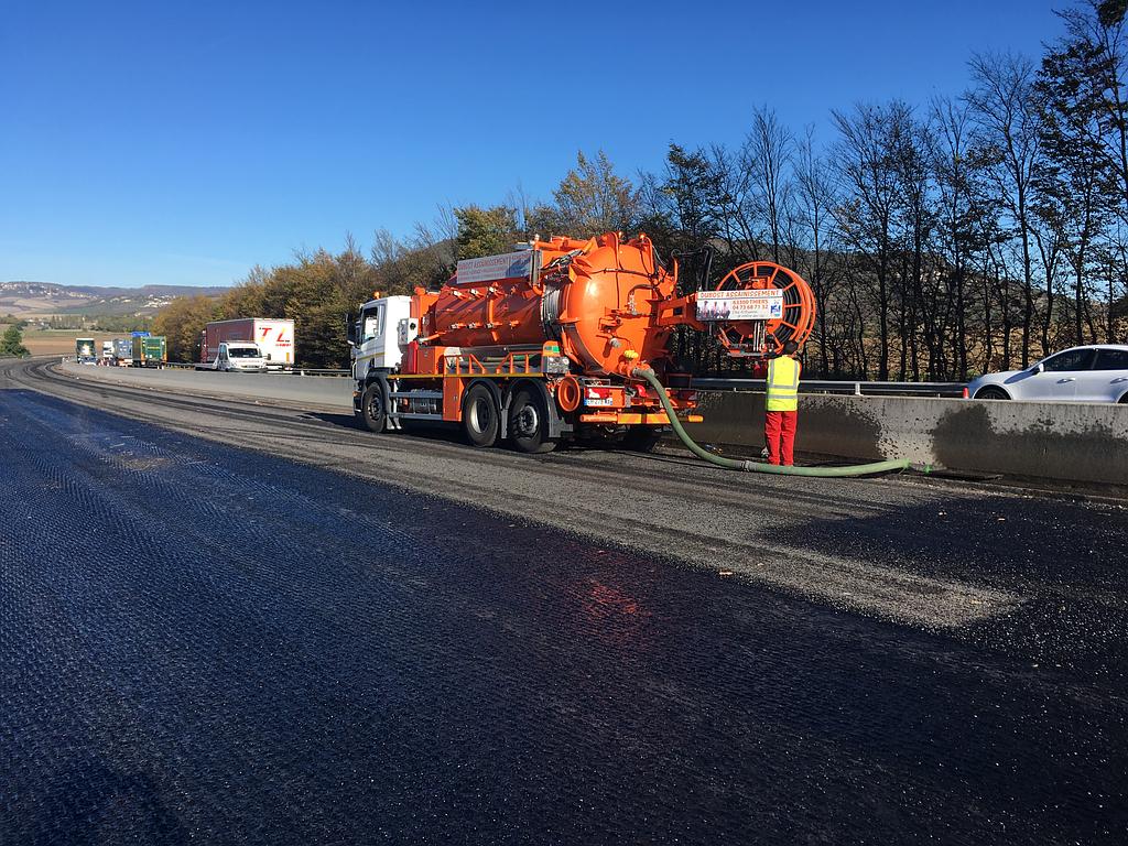 Camion hydrocureur de Dubost Assainissement procédant au nettoyage du caniveau d'une autoroute