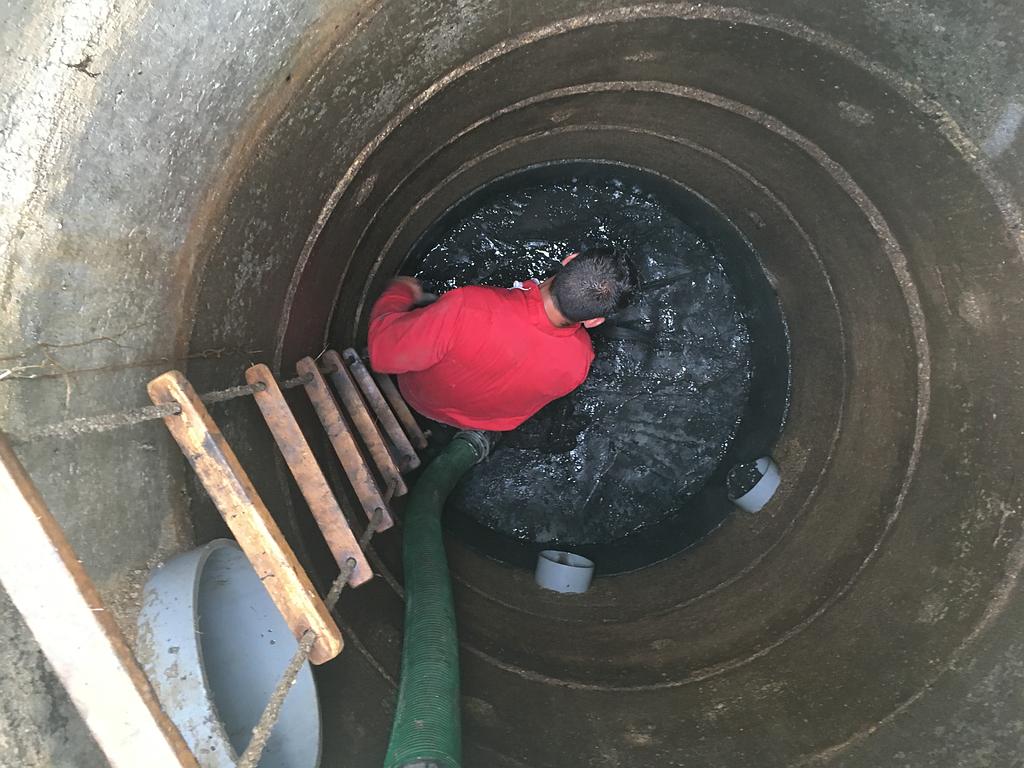 Un employé de Dubost Assainissement au fond d'un puit pour en réaliser la vidange