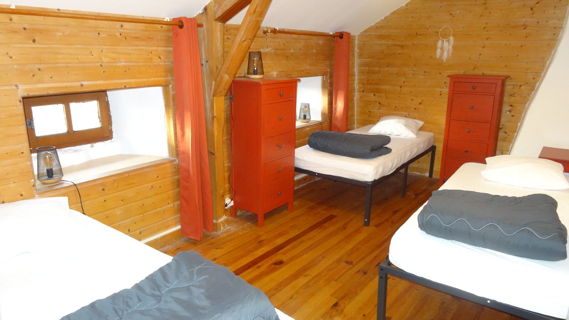 Chambre avec trois lits et murs en lambris