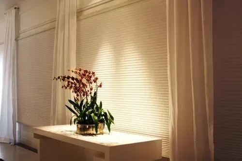 Uma mesa branca com um vaso de flores sobre ela