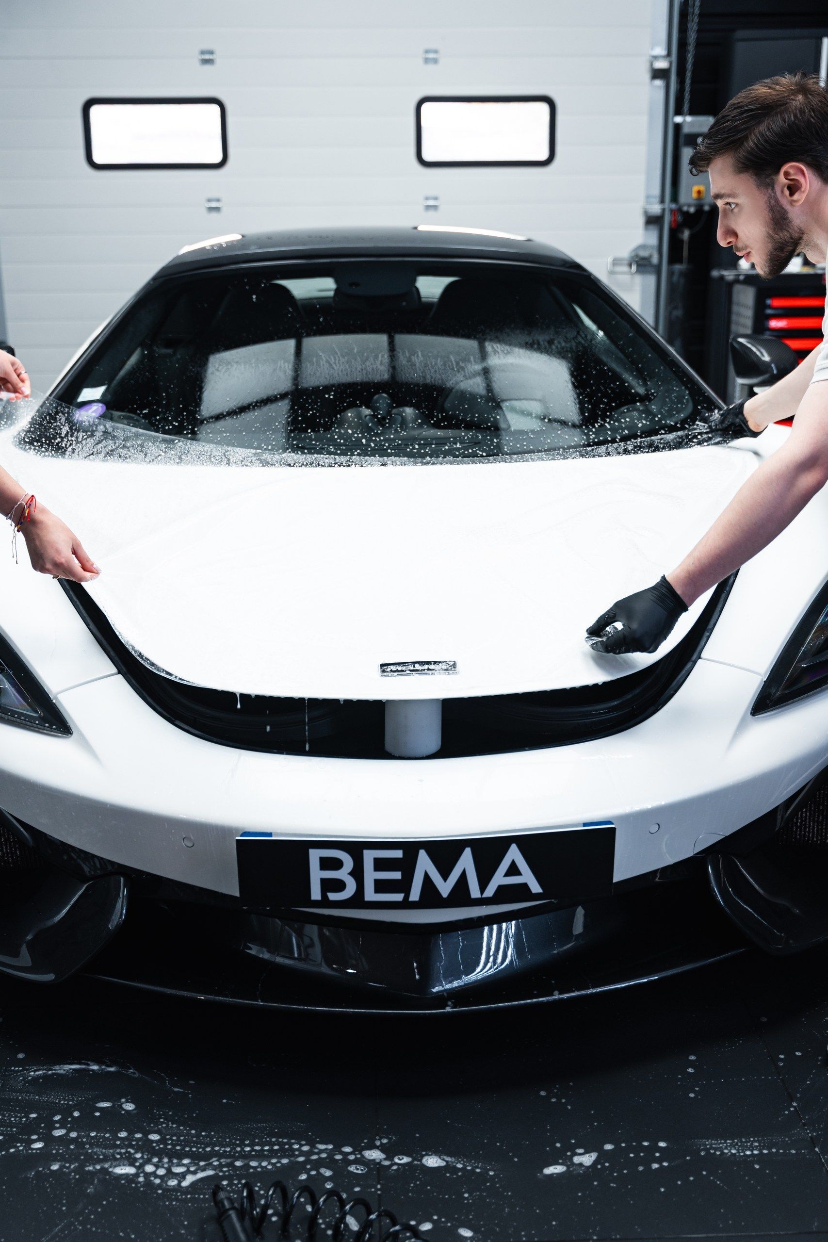 Pose d'un film PPF sur le capot d'un véhicule.